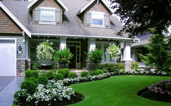 Charming suburban home with landscaped garden, vibrant flowers, and manicured lawn.